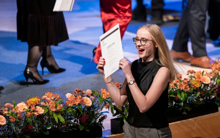 Glad student med diplom.